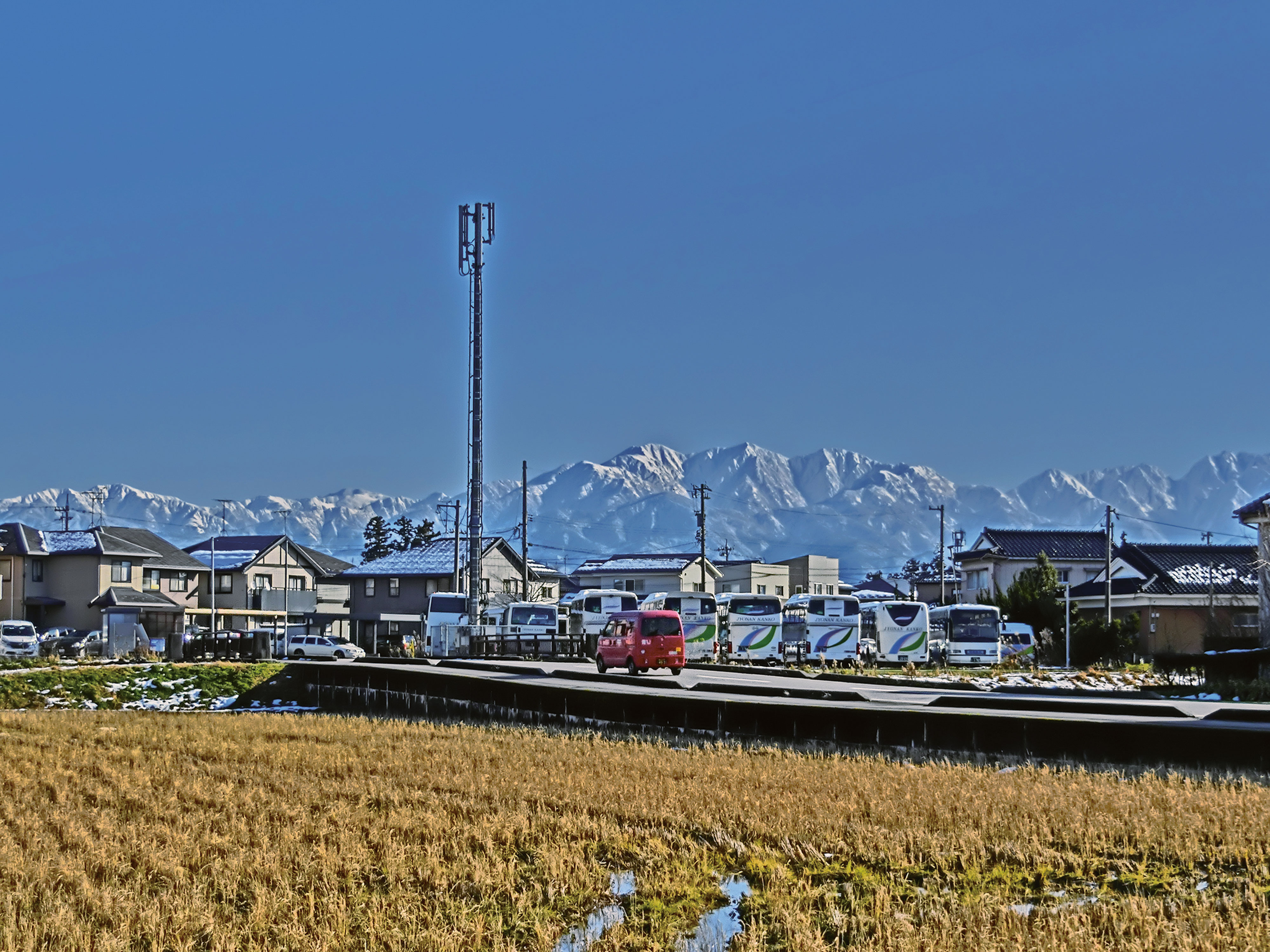 田んぼと住宅街の向こうに立山連峰